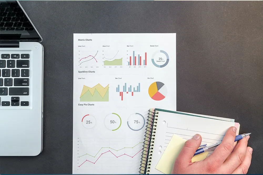 Hand pointing at project charts on paper